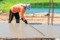 Worker using long triangle trowel to spread and plastering cement on the floor Royalty Free Stock Photo