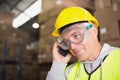 Worker using mobile phone in warehouse Royalty Free Stock Photo