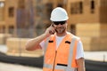 Worker using phone, builder taking on phone a break from work. Architect with mobile phone. Construction site worker in Royalty Free Stock Photo