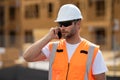 Worker using phone, builder taking on phone a break from work. Architect with mobile phone. Engineer worker in builder Royalty Free Stock Photo