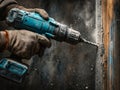 Worker using a power drill to demolish a wall with visible dust and debris Royalty Free Stock Photo