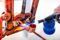 worker using propane gas torch for soldering copper pipes.