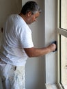 Worker using a putty knife, rear view. Royalty Free Stock Photo