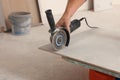 Worker using saw with circular diamond blade for tile cutting indoors, closeup