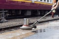 Worker using scrubber machine for cleaning and polishing floor. Cleaning maintenance train at railway station