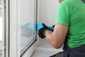 Worker using spatula for double glazing window installation indoors, closeup Royalty Free Stock Photo