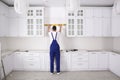 Worker using spirit level while installing new furniture in kitchen