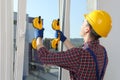 Worker using suction lifters during plastic window installation indoors Royalty Free Stock Photo