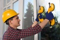 Worker using suction lifters during plastic window installation indoors Royalty Free Stock Photo