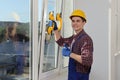 Worker using suction lifters during plastic window installation indoors Royalty Free Stock Photo