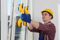 Worker using suction lifters during plastic window installation indoors Royalty Free Stock Photo