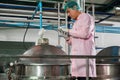 Worker using tablet in beverage factory oversees soda water filling