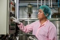 Worker using tablet in beverage factory oversees soda water filling