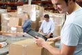 Worker Using Tablet Computer In Distribution Warehouse Royalty Free Stock Photo