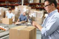 Worker Using Tablet Computer In Distribution Warehouse Royalty Free Stock Photo