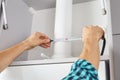 Worker using tape measure while installing new furniture in kitchen. carpenter assembles and installs furniture Royalty Free Stock Photo