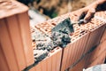 Worker using trowel and tools for building exterior walls with bricks and mortar