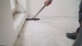 Building cleaning service. dust removal with vacuum cleaner. A worker vacuums the construction floor