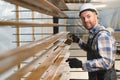 A worker varnishes boards for the construction of a wooden house. Royalty Free Stock Photo