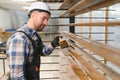 A worker varnishes boards for the construction of a wooden house. Royalty Free Stock Photo