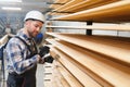 A worker varnishes boards for the construction of a wooden house. Royalty Free Stock Photo