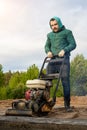 A worker with a vibrating tamping machine rams the ground