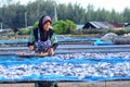 A worker was busy drying the fish for the process of drying the fish under the sun's heat before it became salted fish.