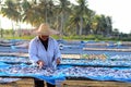 A worker was busy drying the fish for the process of drying the fish under the sun's heat before it became salted fish.