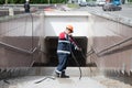worker washes tiles on the walls in an underpass in Moscow, Russia