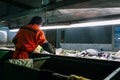 Worker at a waste processing plant. A man sorts rubbish with his hands. Sorting tape. The business of sorting and recycling