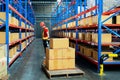 Worker wear safety helmet and holding clipboard and push cart in warehouse store. male warehouse worker checking storage box Royalty Free Stock Photo