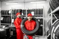 Worker wearing car tire in the storage Royalty Free Stock Photo