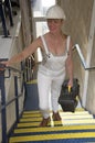 Worker wearing dungarees walking up a flight of stairs Royalty Free Stock Photo