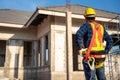 A worker wearing fall protection safety clothing with hooks at construction site. Safety body construction, Working at height