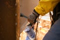 Worker wearing a glove using socket tensioning nut attached into the structure metal wall
