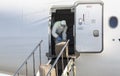 A worker wearing a protective gear unloads personal protection equipment from a plane Royalty Free Stock Photo