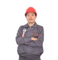 Worker wearing a red hard hat holding a wrench in hand standing in front of white background with his arms Royalty Free Stock Photo