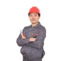 Worker wearing a red hard hat holding a wrench in hand standing in front of white background with his arms Royalty Free Stock Photo