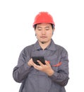 Worker wearing red hard hat is using calculator to calculate Royalty Free Stock Photo