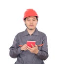 Worker wearing red hard hat is using calculator to calculate Royalty Free Stock Photo