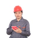 Worker wearing red hard hat is using calculator to calculate Royalty Free Stock Photo