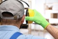 Worker wearing safety headphones indoors, back view. Hearing protection device Royalty Free Stock Photo