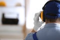 Worker wearing safety headphones indoors, back view with space for text. Hearing protection device Royalty Free Stock Photo