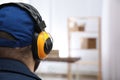 Worker wearing safety headphones indoors, closeup. Hearing protection device Royalty Free Stock Photo
