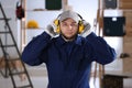 Worker wearing safety headphones indoors. Hearing protection device Royalty Free Stock Photo