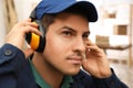 Worker wearing safety headphones indoors. Hearing protection device Royalty Free Stock Photo