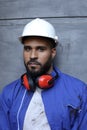 Worker wearing uniform, white hardhat and ear mufflers