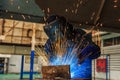 Worker is welding automotive part in car factory