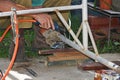 Worker with a welding machine fixing a caster wheels, fiery sparks flying around