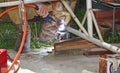 Worker with a welding machine fixing a caster wheels, fiery sparks flying around